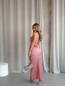 Femme portant avec une robe longue rose avec dos ouvert