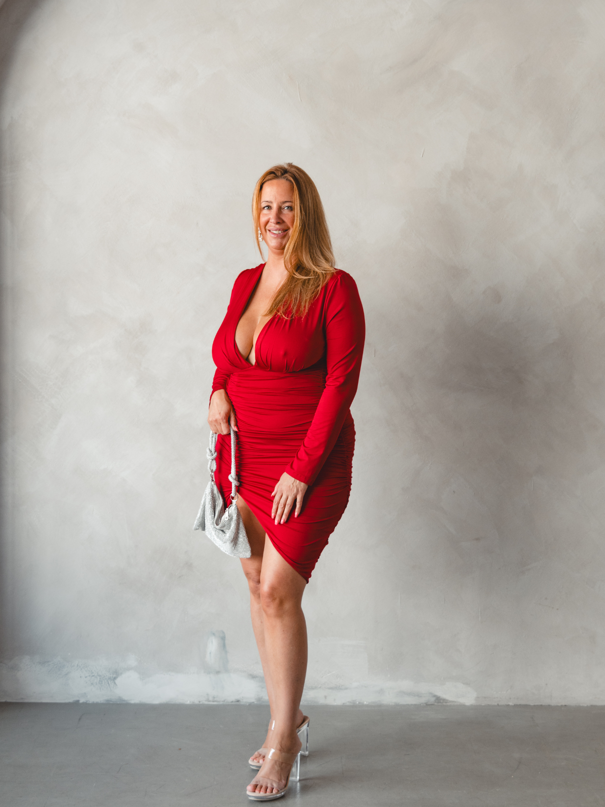 Femme portant une robe midi rouge avec talons transparents