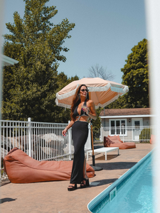 Femme portant une robe longue noire au bord de piscine